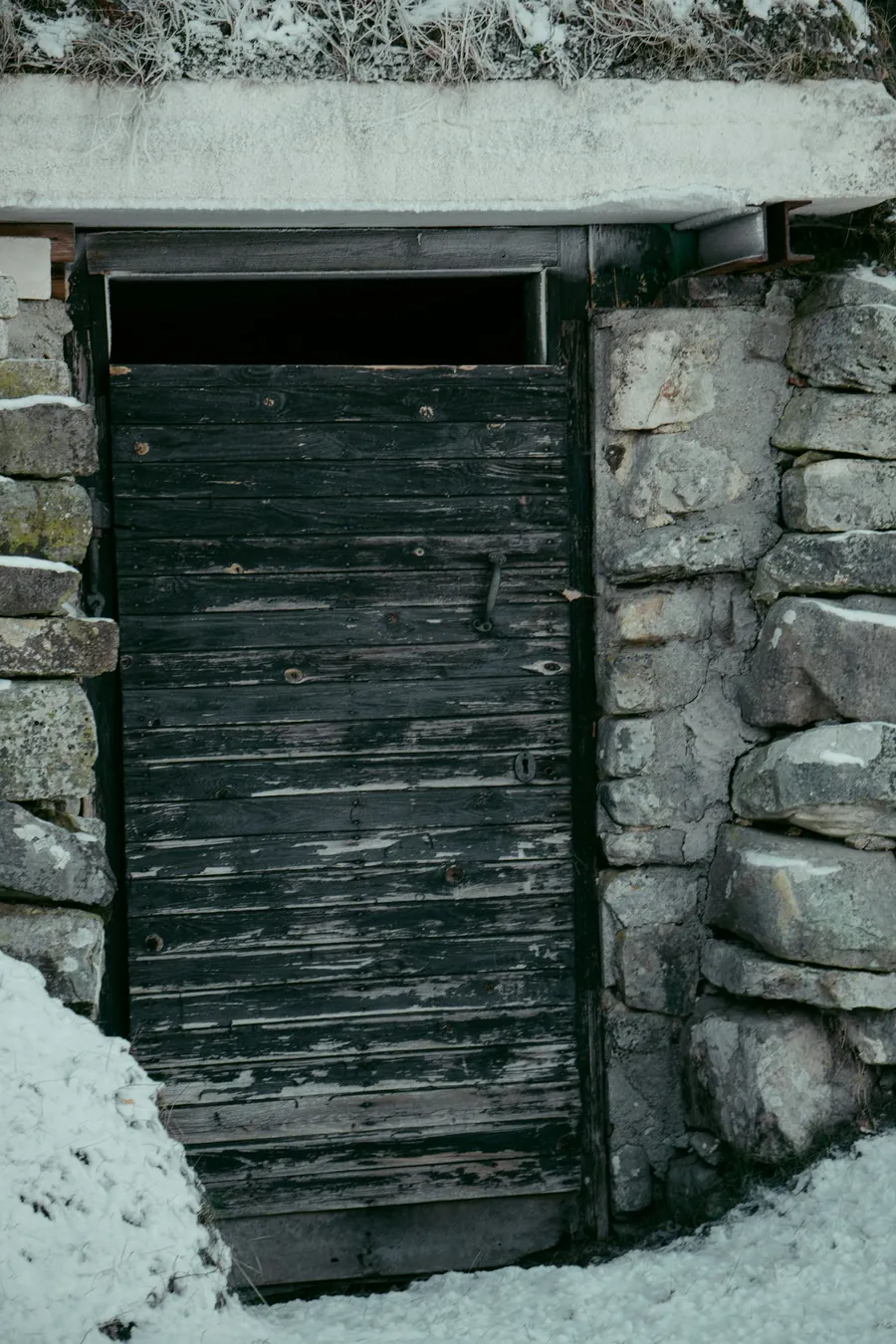 La porta in legno della cantina scavata nella roccia